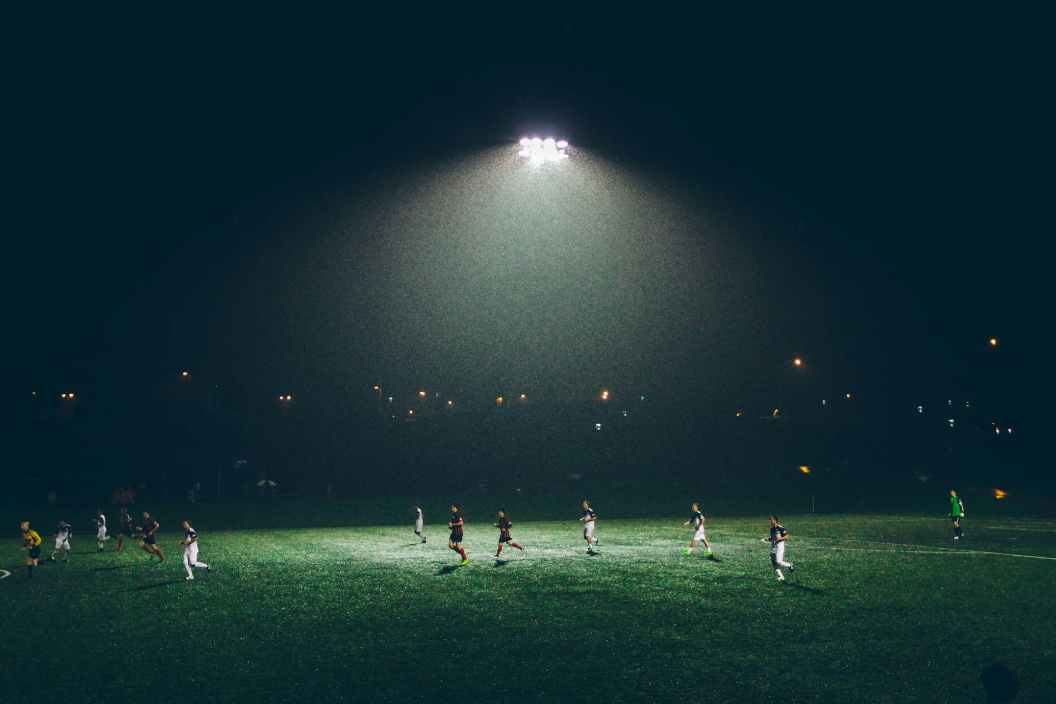 Players competing under stadium floodlights at night