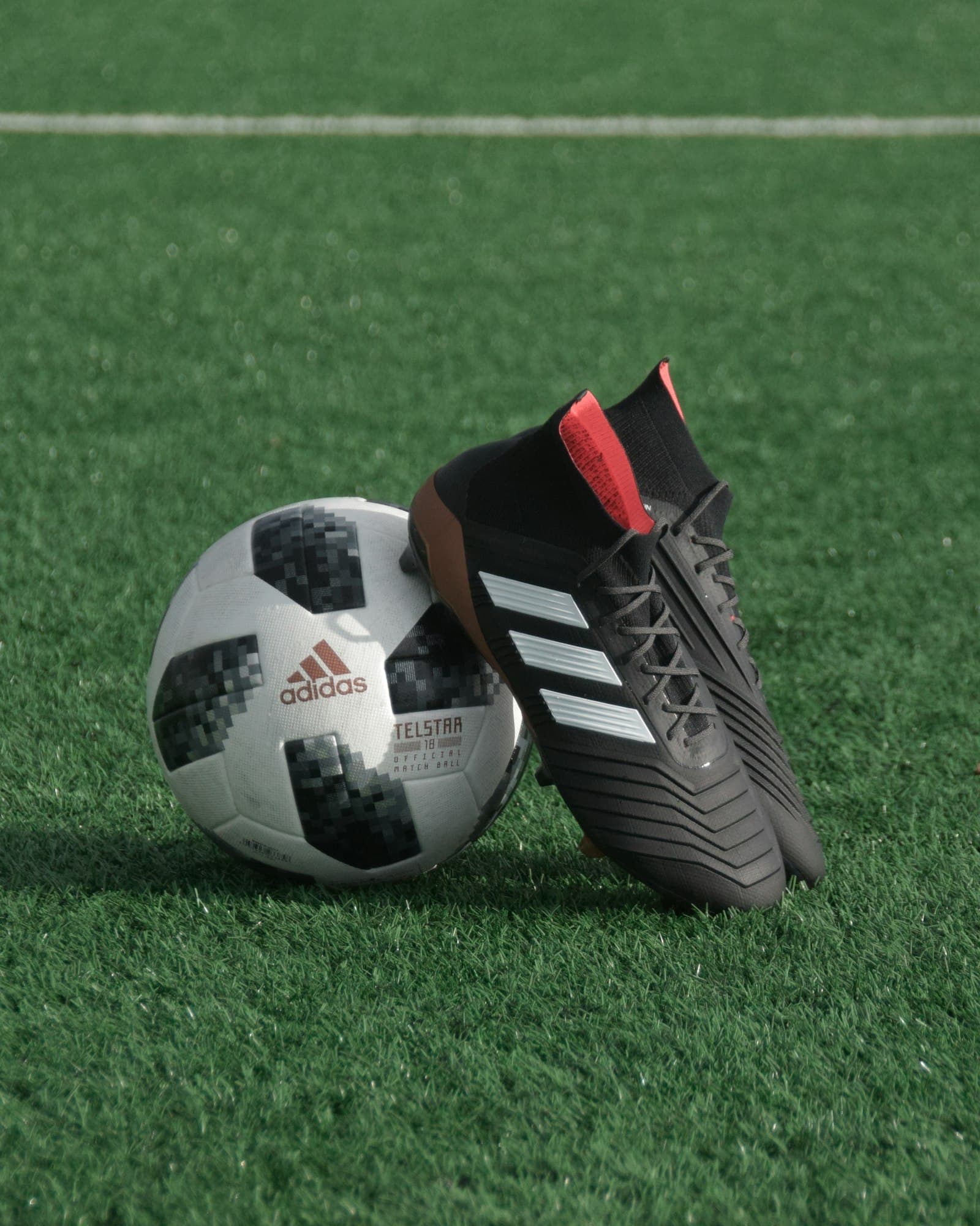 Soccer cleats beside a ball on grass