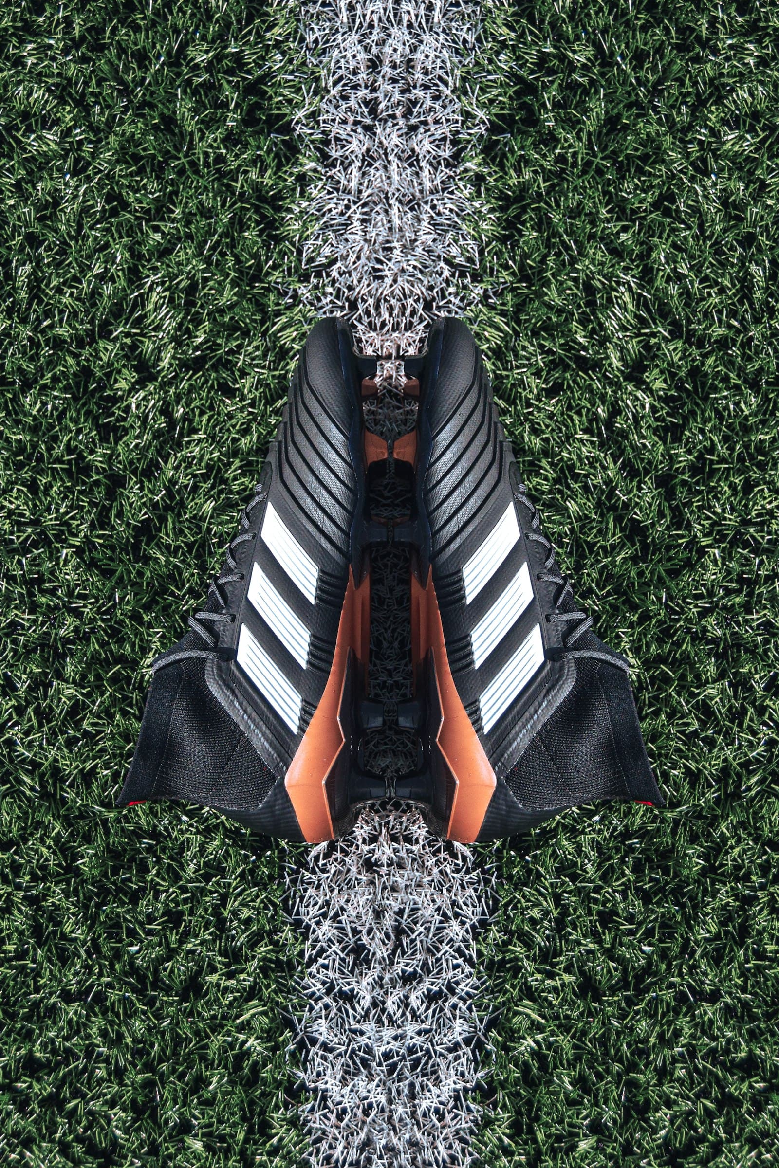 Black soccer cleats on a grass field